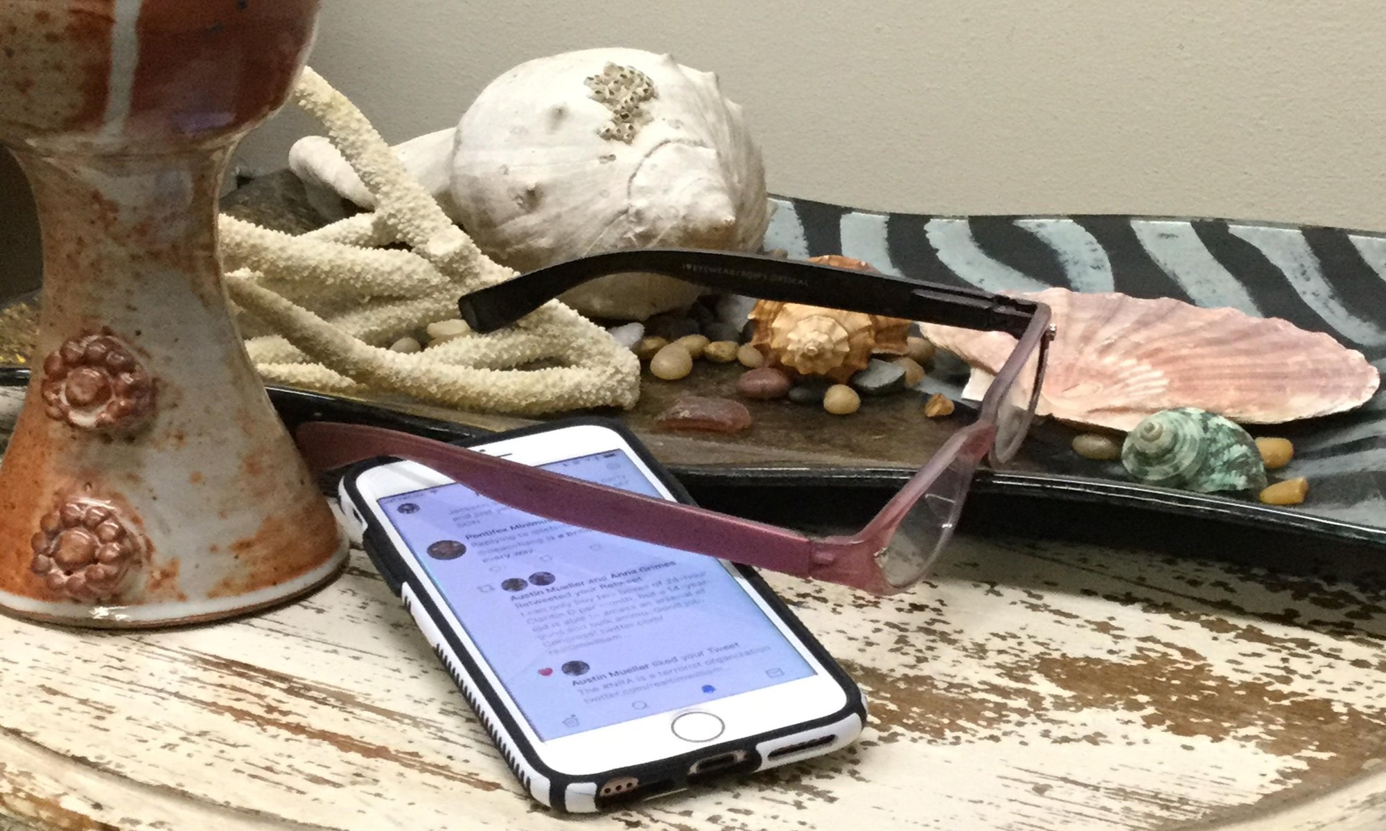 Chalice, phone and shells on a table